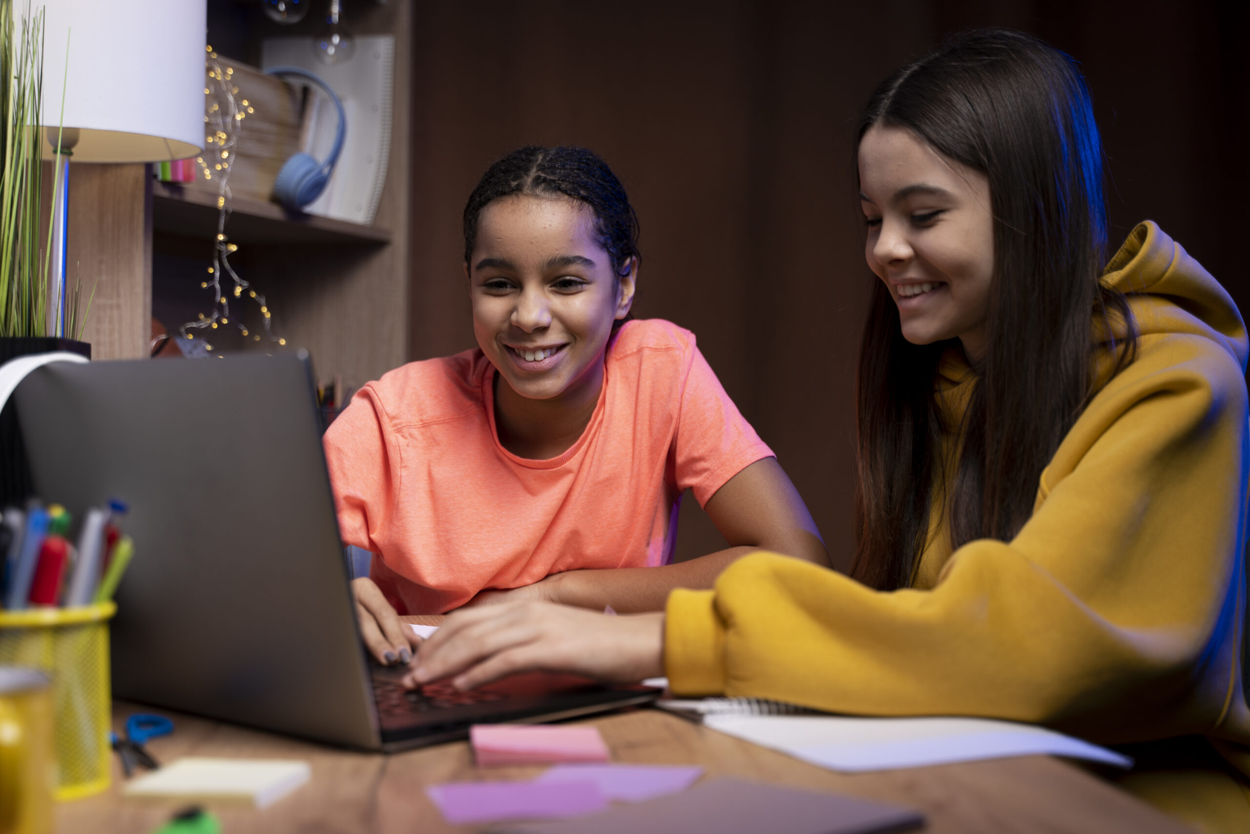 Two teenage girls studying together checking out our plans